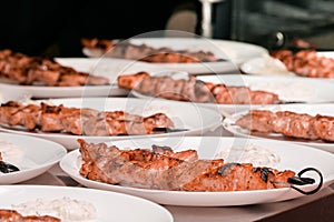 Meat grilled on skewers in plates , a lot of servings. Greek cuisine. souvlaki