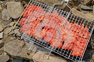 The meat is laid on a grill and set on hot charcoal.