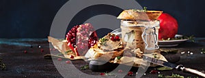 Meat liver pate on toasted bread with fruit seeds and spice herb, brown kitchen table, copy space, selective focus