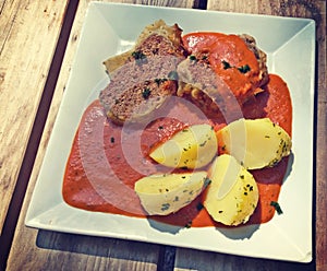 Meat loaf with boiled potatoes and tomato sauce
