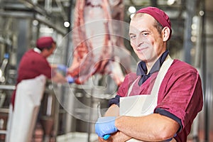 Meat manufacturing factory. Portrait of young butcher