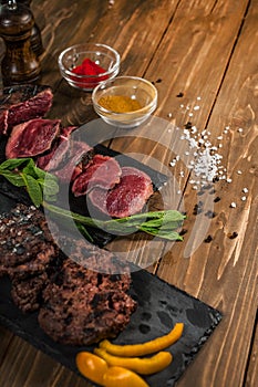 Meat, mint, grilled burgers, on a wooden table.