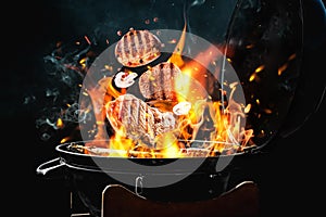 Meat and mushrooms falling onto barbecue grill with flame against background, closeup