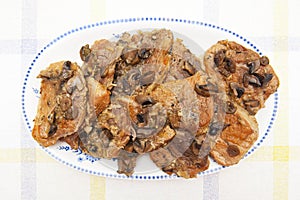 Meat with mushrooms on white plate