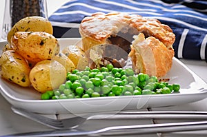 Meat pie with new potatoes and peas.
