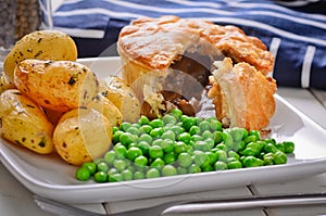 Meat pie with new potatoes and peas. photo