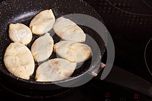 Meat pies, pan-fried in boiling oil. small raw pies in a frying pan with hot oil. copy space for text