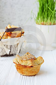 Meat pies from puff pastry with sesame seeds on a light background. Fresh Traditional Australian meat pie.