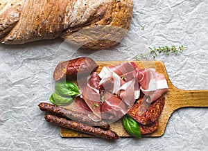 Meat plate on rustic wood board over a rough sackcloth background