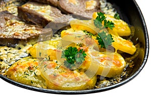Meat and potatoes fried in a pan