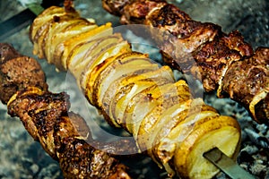 Meat and potatoes on skewers photo