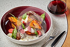 Meat with potatoes and vegetables served at restaurant.