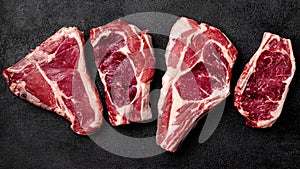 Meat raw steak lies on a black background. top view