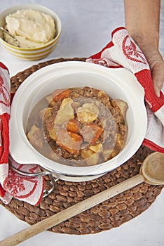 Meat and roasted vegetable stew served in crock pot