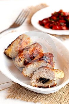 Meat rolls with mushrooms. Roasted Turkey breast rolls with mushrooms on the plate and on the burlap, fork, vegetable salad