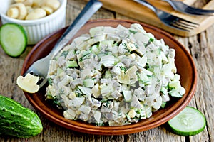 Meat salad with fresh cucumber, marinated mushrooms, boiled eggs