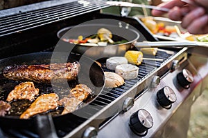 Meat and sausages on the grill. Garden party outside in the backyard.