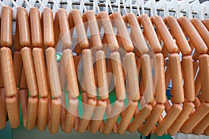 Meat sausages on plastic conveyer in food industry