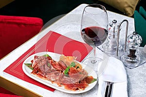 Meat set. jamon, prosciutto and a glass of red wine. Place for text