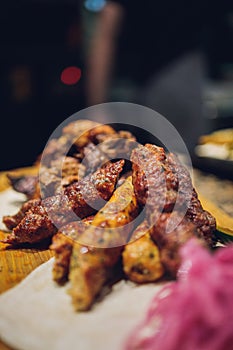 Meat set on a wooden board. Fried chicken wings, pork ribs, grilled vegetables, french fries. Beer appetizer with sauces