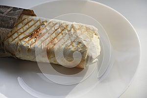 Meat shawarma on a white plate. A meat delicacy. Gyros kebab