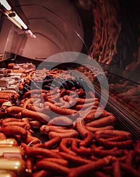 Meat shop's counter with many uncooked fresh meat and sausages