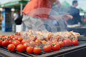 Meat skewers and tomatoes on grill