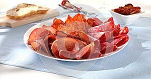 meat slices on a plate. traditional spanish sausage with beef jerky. salchichon, chorizo and prosciutto