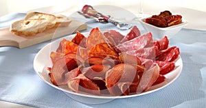 meat slices on a plate. traditional spanish sausage with beef jerky. salchichon, chorizo and prosciutto