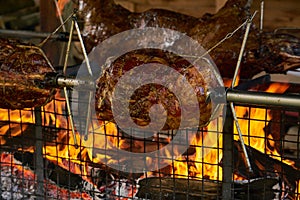 Meat Spit Roasting over the Flames of a log fire