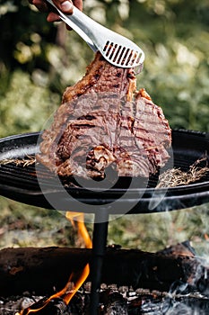meat steak. Fresh raw Prime Black Angus beef steak cooking on flaming grill with smoke