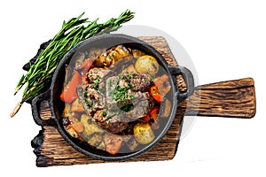 Meat stew in cooking pot on dark rustic cutting board. Isolated on white background, Top view.