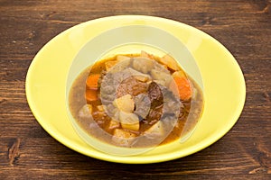 Meat stew and vegetables on wood