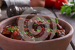 Meat in tomato sauce beef roast in a clay bowl