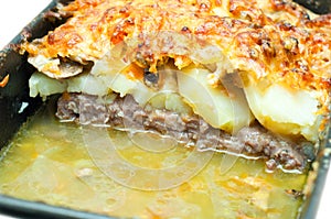 Meat topped with potatoes mushrooms photo