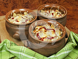 Meat and vegetables with cheese and ketchup in pots