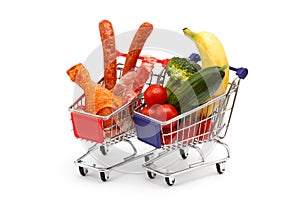 Meat and vegetables in two shopping carts, isolated on white