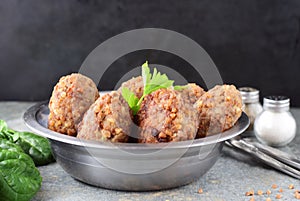 Meatballs with buckwheat in a metal bowl on a grey abstract background.Healthy food.Healthy eating concept.