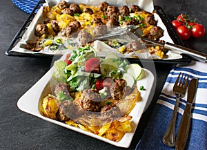 Meatballs with roasted potatoes and salad photo