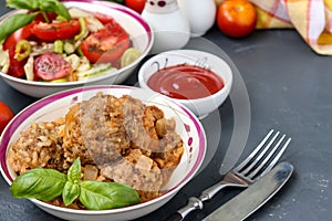 Meatballs in sour cream and tomatoes sauce in bowls against a dark background, horizontal orientation