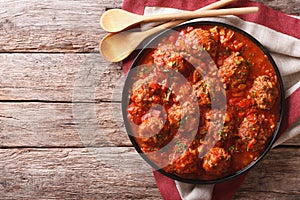 Meatballs with spicy tomato sauce on a plate on the table. horizontal top view