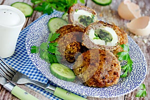 Meatballs stuffed with boiled eggs and green herbs butter