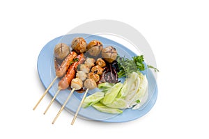 Meatballs toasted on wood dish and a sauce decorated with coriander placed isolated on white background