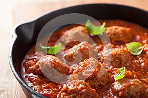 Meatballs with tomato sauce in black pan