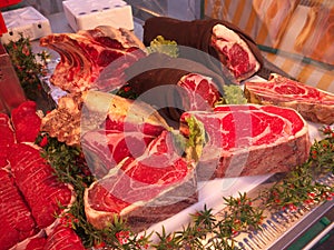 Meats sold at Street market in Paris. People walking and buying food