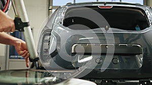 Mechanic adding glue to the windscreen of a car windshield replacement station