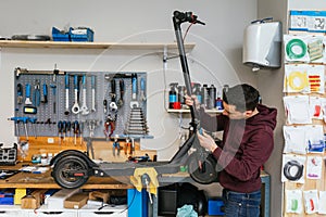 Mechanic adjusting the handlebar of an electric scooter.