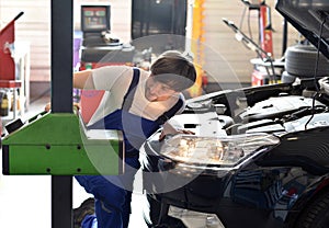 Mechanic adjusts headlights from the car in a workshop photo