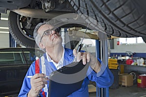Mechanic analyzing car engine at auto repair shop