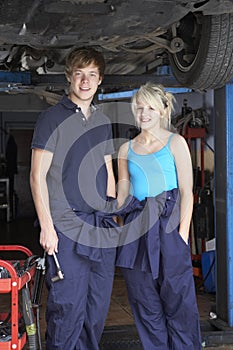 Mechanic and apprentice working on car